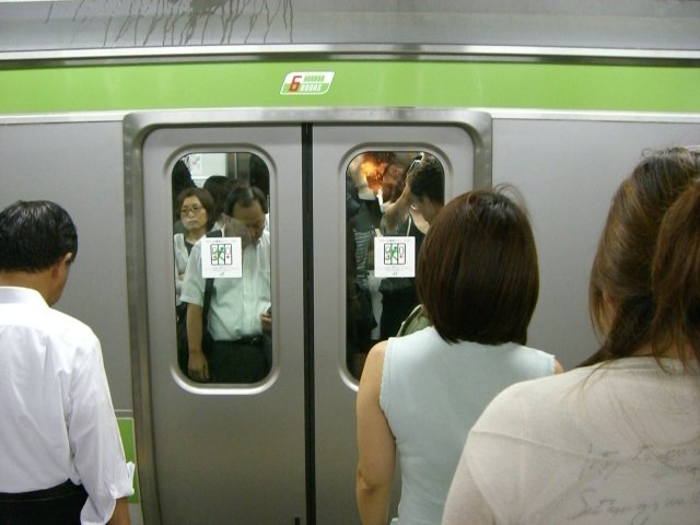 Gente esperando el metro en Japón